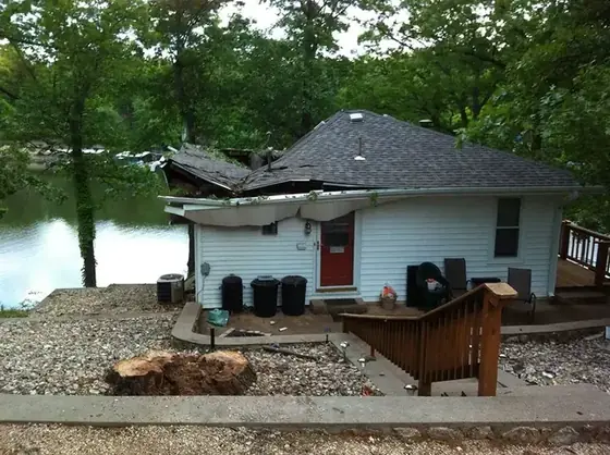 A cleared lakefront property, gravel drive graded with the lake behind it